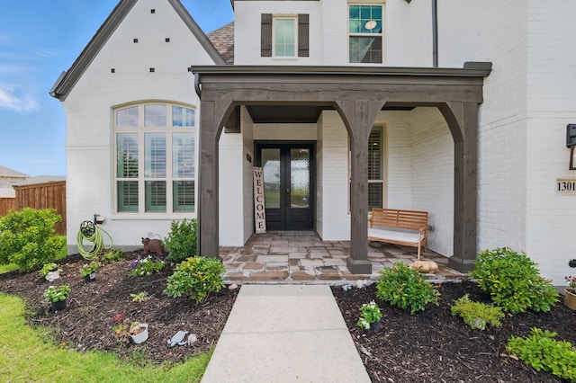 1301 Limestone Ridge Rd, Mansfield, TX 76063 - doorway to property with french doors, brick siding, and covered porch