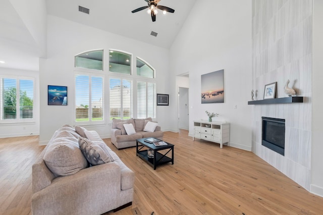 1301 Limestone Ridge Rd, Mansfield, TX 76063 - living area featuring high vaulted ceiling, a large fireplace, light wood-style flooring, ceiling fan, and baseboards