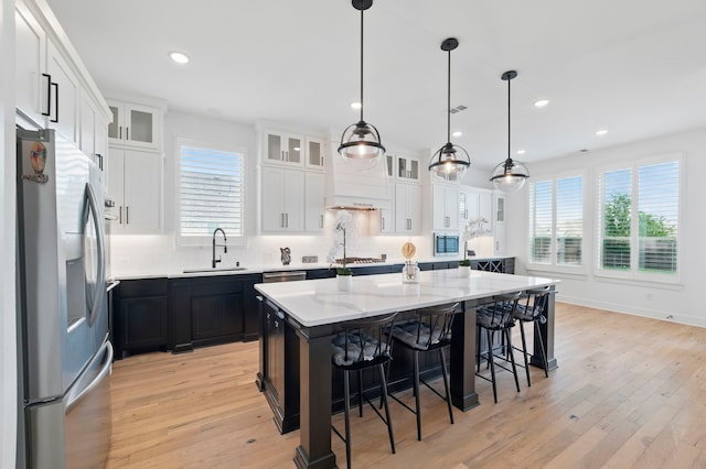 1301 Limestone Ridge Rd, Mansfield, TX 76063 - kitchen with stainless steel appliances, a sink, a center island, light wood-type flooring, and recessed lighting