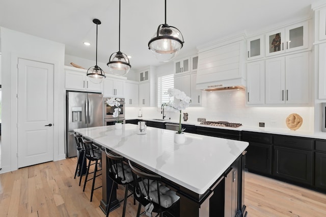 1301 Limestone Ridge Rd, Mansfield, TX 76063 - kitchen featuring appliances with stainless steel finishes, dark cabinetry, a center island, white cabinetry, and a breakfast bar