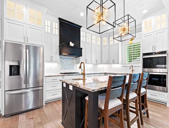 9035 Shallow Cv, Tyler, TX 75703 - kitchen featuring appliances with stainless steel finishes, a chandelier, a center island with sink, light wood-style flooring, and recessed lighting