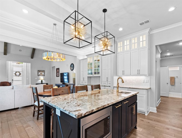9035 Shallow Cv, Tyler, TX 75703 - kitchen with a chandelier, a sink, stainless steel microwave, crown molding, and pendant lighting