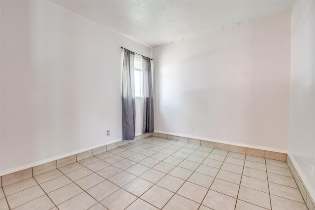 1709 Meadow Vly, Irving, TX 75060 - spare room featuring light tile patterned flooring, a textured ceiling, and baseboards