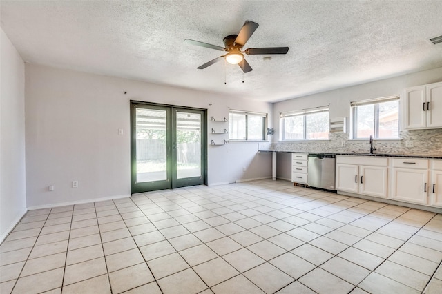 1709 Meadow Vly, Irving, TX 75060 - kitchen with dishwasher, a sink, a ceiling fan, white cabinets, and decorative backsplash