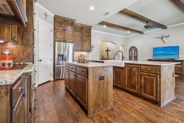 114 Piper Pkwy, Waxahachie, TX 75165 - kitchen with stainless steel refrigerator with ice dispenser, a center island with sink, a sink, beam ceiling, and black electric stovetop