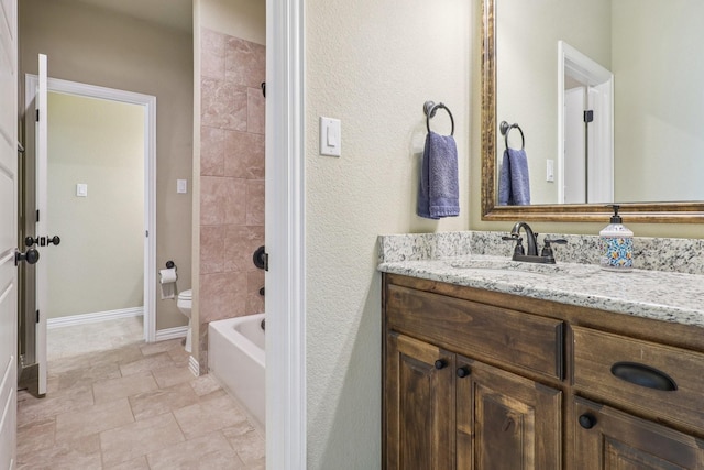 114 Piper Pkwy, Waxahachie, TX 75165 - bathroom with vanity, toilet, stone finish floors, washtub / shower combination, and baseboards