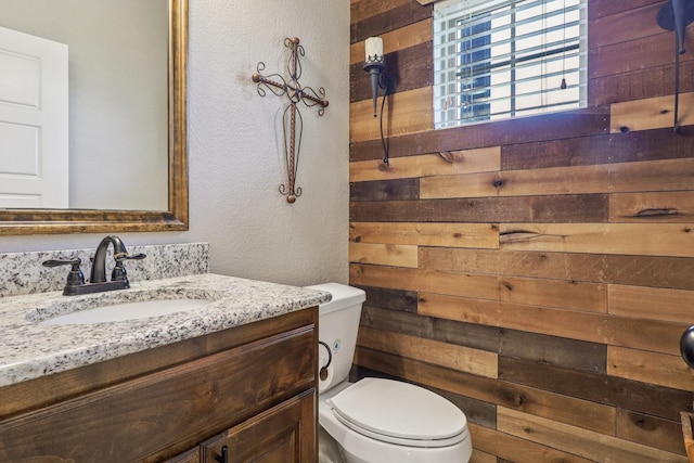 114 Piper Pkwy, Waxahachie, TX 75165 - half bath with wooden walls, vanity, toilet, and a textured wall