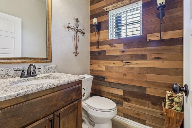 114 Piper Pkwy, Waxahachie, TX 75165 - half bathroom featuring wood walls, toilet, and vanity