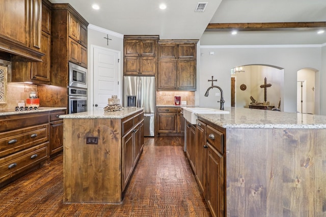 114 Piper Pkwy, Waxahachie, TX 75165 - kitchen with a center island with sink, appliances with stainless steel finishes, backsplash, a sink, and recessed lighting