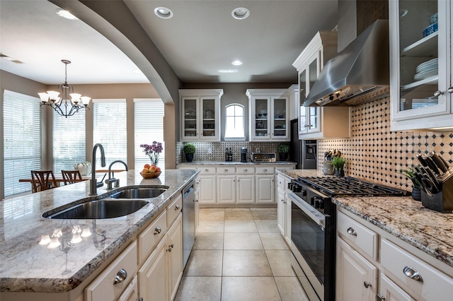 6312 Valley View Dr, Mckinney, TX 75071 - kitchen featuring wall chimney range hood, gas stove, a sink, a chandelier, and backsplash