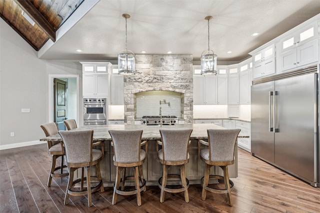 12877 Foutch Rd, Pilot Point, TX 76258 - kitchen featuring appliances with stainless steel finishes, baseboards, a center island with sink, a chandelier, and white cabinetry