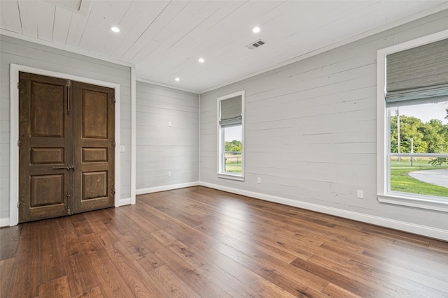 12877 Foutch Rd, Pilot Point, TX 76258 - empty room with baseboards, wood-type flooring, plenty of natural light, recessed lighting, and wood walls