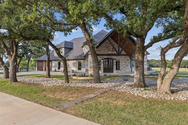12877 Foutch Rd, Pilot Point, TX 76258 - view of front of house featuring stone siding, a garage, a front yard, and concrete driveway