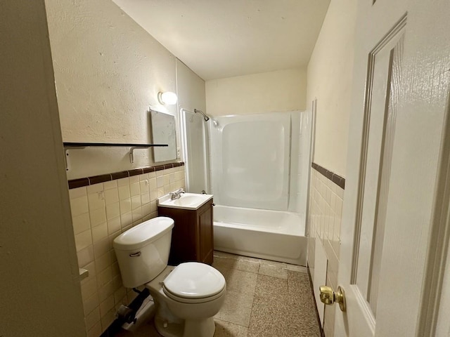 1517 Maple Dr, Garland, TX 75042 - bathroom with tile walls, toilet, vanity,  shower combination, and wainscoting