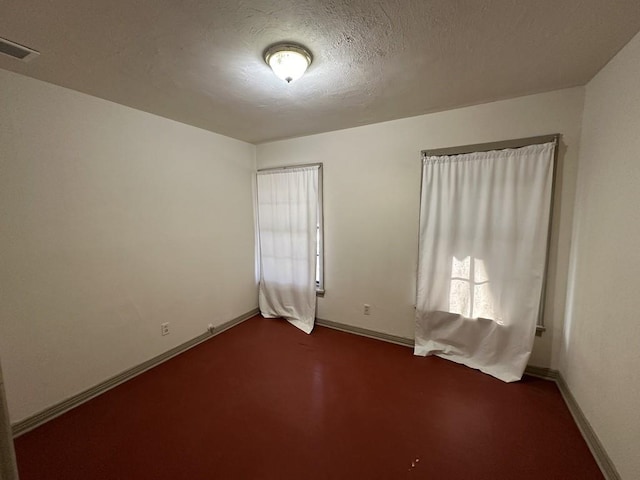 1517 Maple Dr, Garland, TX 75042 - unfurnished room with baseboards, a textured ceiling, and dark colored carpet