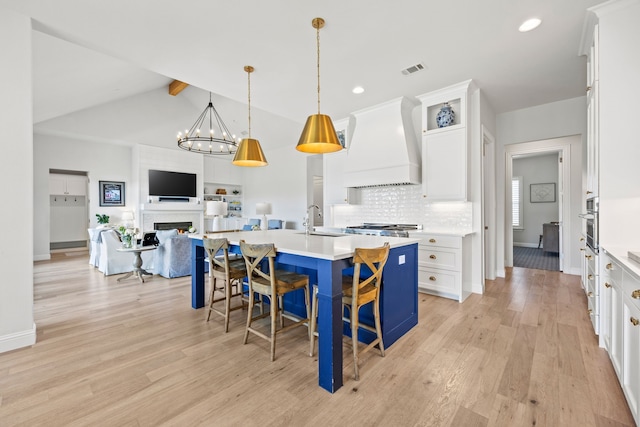 3201 Dovehill Dr, Northlake, TX 76247 - kitchen with custom exhaust hood, light wood finished floors, a chandelier, white cabinetry, and light countertops