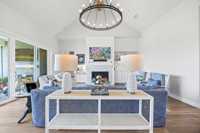 3201 Dovehill Dr, Northlake, TX 76247 - living room with vaulted ceiling, a chandelier, wood finished floors, a glass covered fireplace, and baseboards