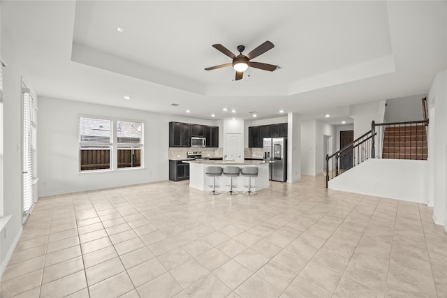 1028 W Dr, Aubrey, TX 76227 - unfurnished living room featuring a tray ceiling, ceiling fan, recessed lighting, stairway, and light tile patterned floors