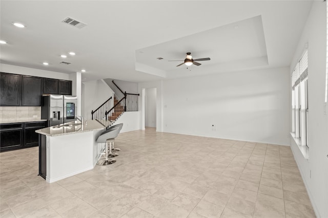1028 W Dr, Aubrey, TX 76227 - kitchen featuring stainless steel refrigerator with ice dispenser, a ceiling fan, a raised ceiling, recessed lighting, and backsplash