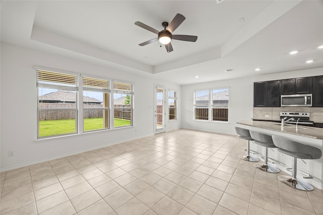 1028 W Dr, Aubrey, TX 76227 - living room with a raised ceiling, ceiling fan, recessed lighting, light tile patterned flooring, and baseboards
