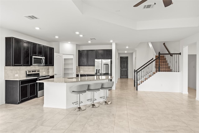 1028 W Dr, Aubrey, TX 76227 - kitchen with appliances with stainless steel finishes, dark cabinets, tasteful backsplash, a sink, and ceiling fan