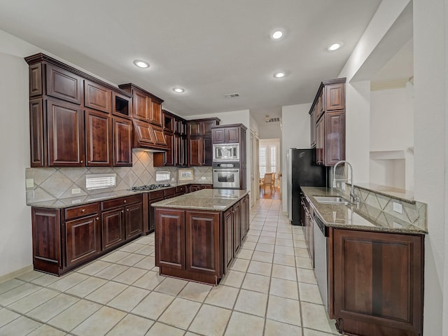 8009 Marathon Dr, Plano, TX 75024 - kitchen featuring appliances with stainless steel finishes, backsplash, light stone counters, recessed lighting, and light tile patterned floors