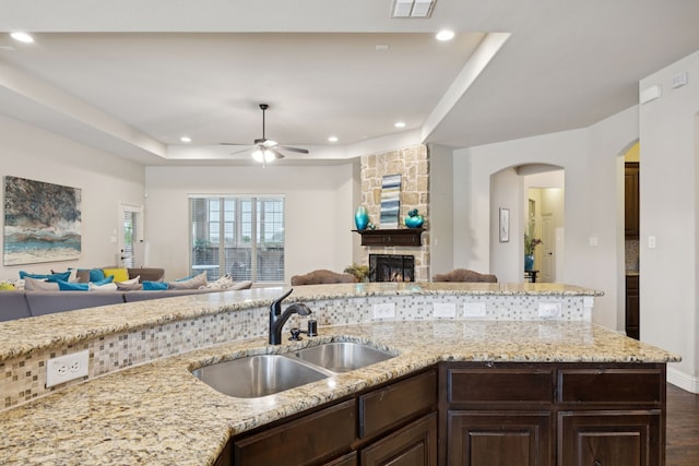 235 Bearclaw Cir, Aledo, TX 76008 - kitchen featuring open floor plan, arched walkways, dark brown cabinetry, a ceiling fan, and recessed lighting