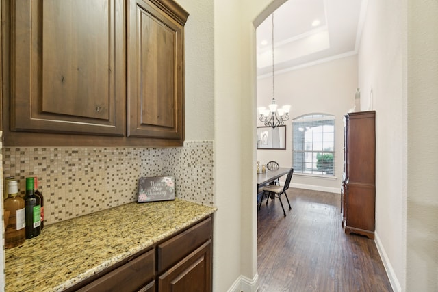 235 Bearclaw Cir, Aledo, TX 76008 - kitchen featuring a chandelier, decorative backsplash, dark wood-style flooring, baseboards, and crown molding