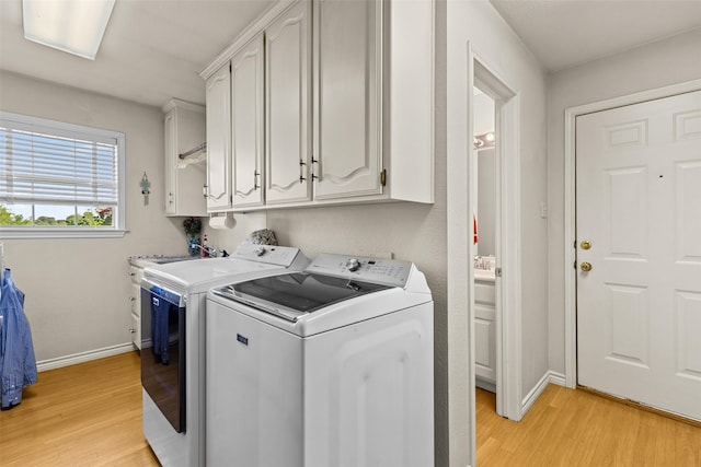 1419 Hinchliffe Rd, Mexia, TX 76667 - laundry area with washing machine and clothes dryer, cabinet space, light wood-style flooring, and baseboards