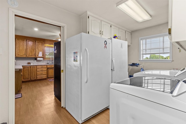 1419 Hinchliffe Rd, Mexia, TX 76667 - kitchen with washer and clothes dryer, freestanding refrigerator, light wood-style flooring, and healthy amount of natural light