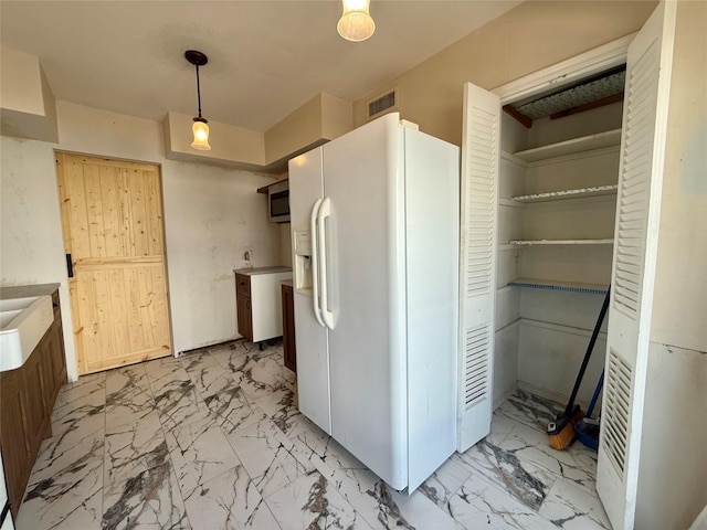 7830 Meadow Park Dr Unit 209, Dallas, TX 75230 - kitchen featuring white refrigerator with ice dispenser, light marble finish floors, and hanging light fixtures