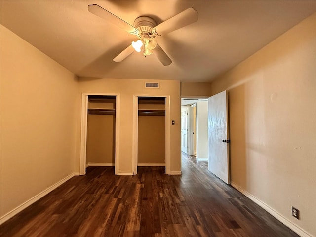 7830 Meadow Park Dr Unit 209, Dallas, TX 75230 - unfurnished bedroom with multiple closets, dark wood finished floors, baseboards, and ceiling fan