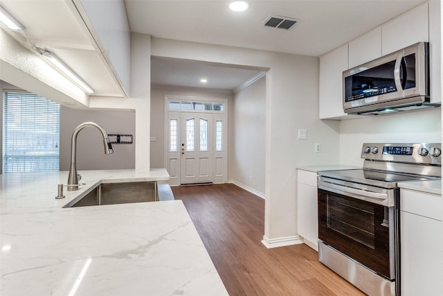 3208 Cole Ave Unit 2203, Dallas, TX 75204 - kitchen featuring stainless steel appliances, a sink, modern cabinets, wood finished floors, and recessed lighting