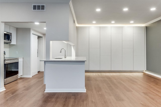 3208 Cole Ave Unit 2203, Dallas, TX 75204 - kitchen with stainless steel appliances, a sink, light wood finished floors, modern cabinets, and light countertops