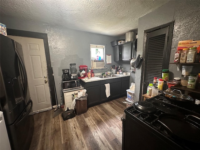 133 E Wanda Dr, Garland, TX 75040 - kitchen featuring black appliances, a textured ceiling, a textured wall, dark wood-style flooring, and a sink