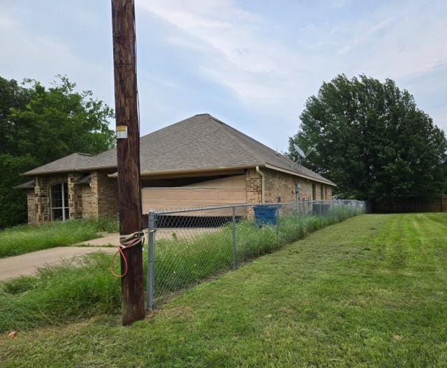view of property exterior featuring an attached garage, driveway, brick siding, and a shingled roof