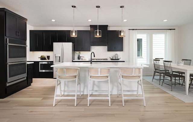 3124 Hoyle, Mckinney, TX 75071 - kitchen featuring appliances with stainless steel finishes, dark cabinetry, light countertops, light wood-style floors, and recessed lighting