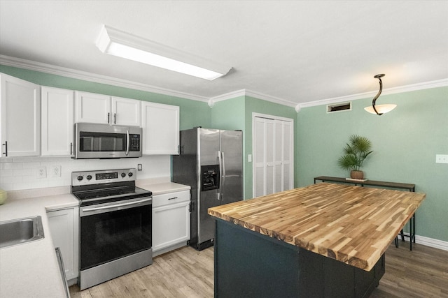 7817 Whirlwind Dr, Fort Worth, TX 76133 - kitchen with stainless steel appliances, ornamental molding, light wood-type flooring, and white cabinetry