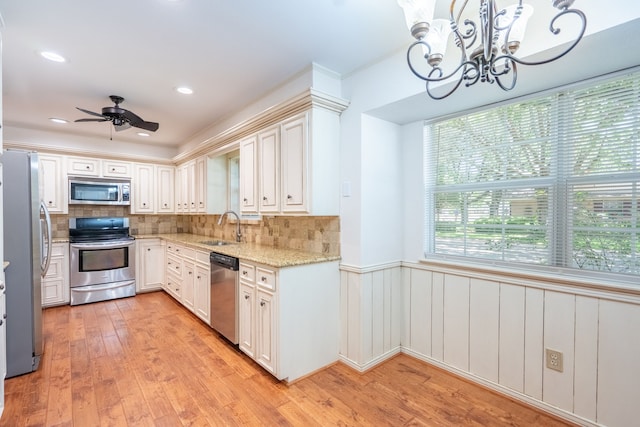 110 Sunview St, Sunnyvale, TX 75182 - kitchen featuring stainless steel appliances, a sink, a chandelier, light stone countertops, and wainscoting