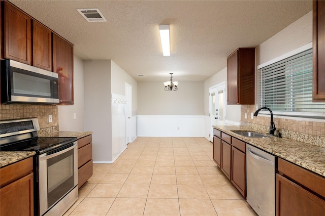 2133 Bliss Rd, Fort Worth, TX 76177 - kitchen featuring stainless steel appliances, a sink, tasteful backsplash, a chandelier, and a textured ceiling