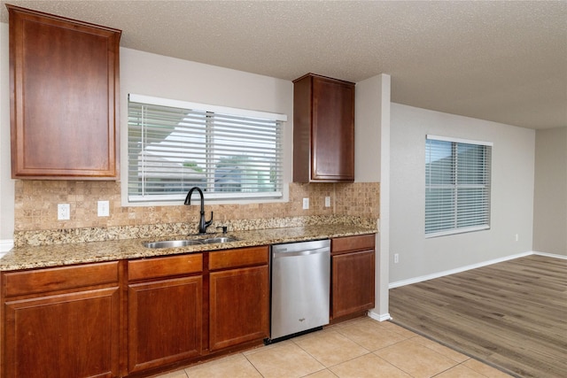 2133 Bliss Rd, Fort Worth, TX 76177 - kitchen with stainless steel dishwasher, a sink, tasteful backsplash, light stone countertops, and a textured ceiling
