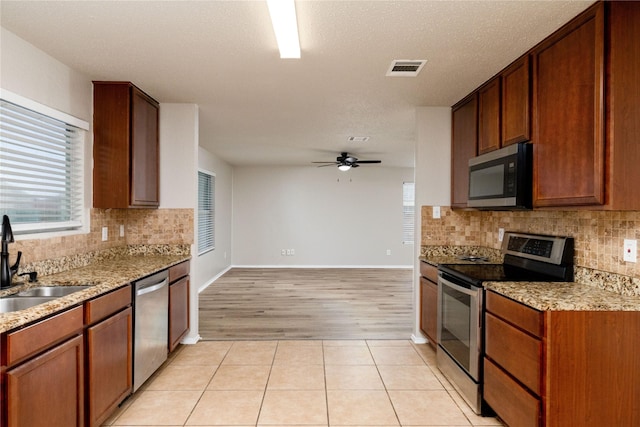 2133 Bliss Rd, Fort Worth, TX 76177 - kitchen with stainless steel appliances, a sink, a ceiling fan, and decorative backsplash