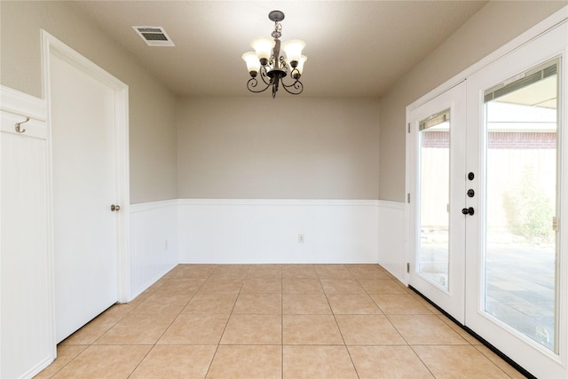 2133 Bliss Rd, Fort Worth, TX 76177 - unfurnished dining area with a wainscoted wall, a chandelier, french doors, and light tile patterned floors
