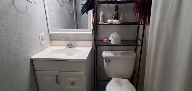 918 Greenbriar Dr, Garland, TX 75043 - bathroom featuring a textured wall, vanity, and toilet
