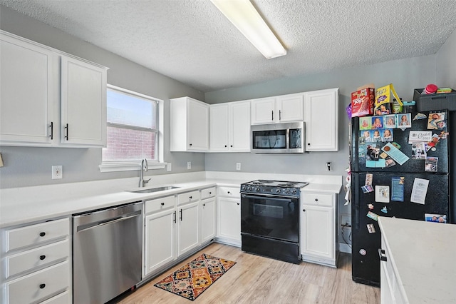 2748 Yoakum St, Fort Worth, TX 76108 - kitchen featuring black appliances, a sink, a textured ceiling, light wood-style floors, and white cabinetry