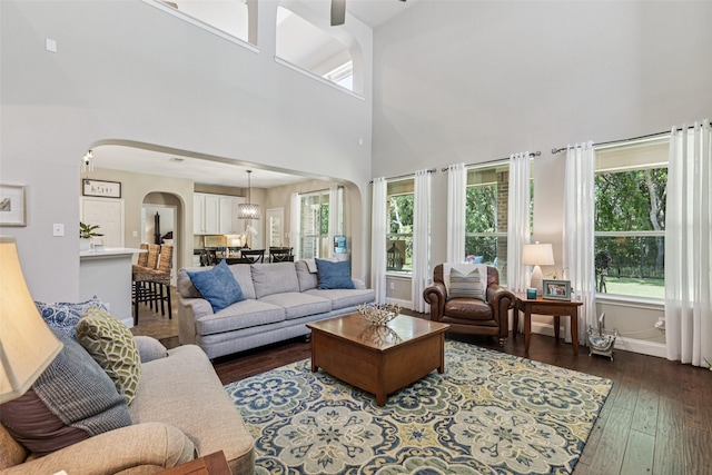 11310 Seguin Dr, Frisco, TX 75035 - living area featuring arched walkways, a high ceiling, dark wood-type flooring, baseboards, and a ceiling fan