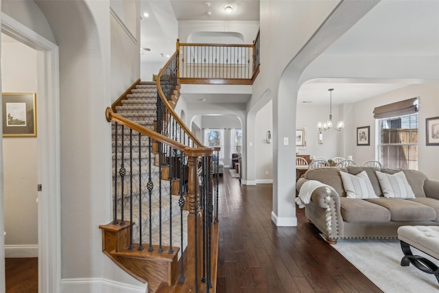 11310 Seguin Dr, Frisco, TX 75035 - living room with arched walkways, a chandelier, hardwood / wood-style flooring, healthy amount of natural light, and a high ceiling