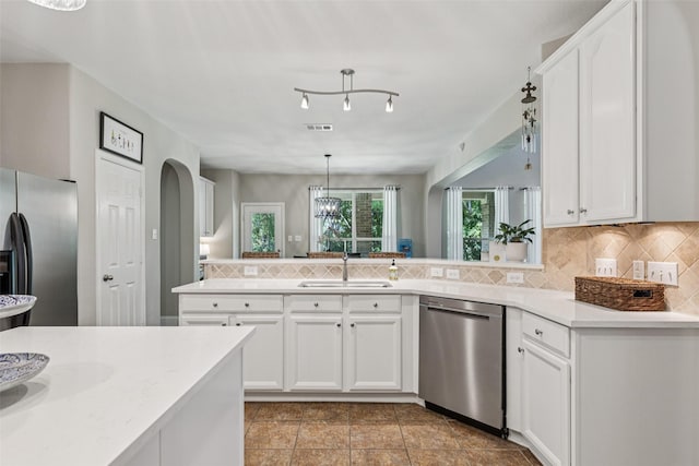 11310 Seguin Dr, Frisco, TX 75035 - kitchen with appliances with stainless steel finishes, a sink, backsplash, light countertops, and white cabinetry