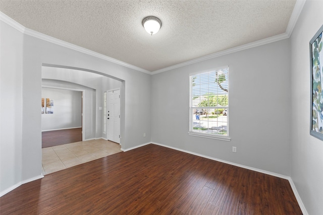 1106 Brook Ridge Ave, Allen, TX 75002 - empty room featuring wood finished floors, a textured ceiling, arched walkways, ornamental molding, and baseboards