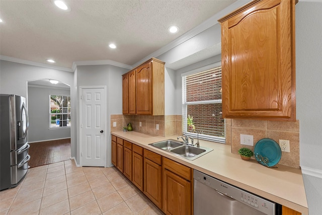 1106 Brook Ridge Ave, Allen, TX 75002 - kitchen with stainless steel appliances, a sink, arched walkways, light tile patterned floors, and backsplash